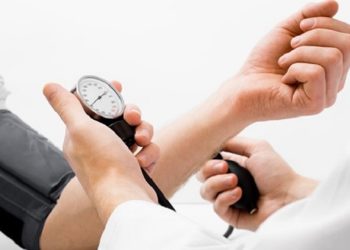 Doctor measuring blood pressure - studio shot on white background